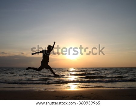 Happy man Jumping in Sea Sunset