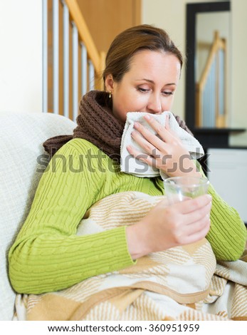 Girl with scarf, blanket and dissolving medicine in glass