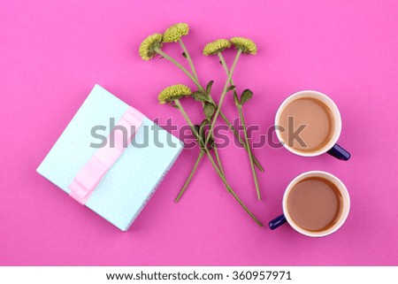 Gift box with flowers on pink background