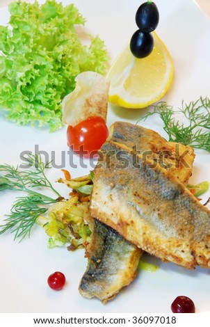 grilled fish on a plate with tomato and herbs