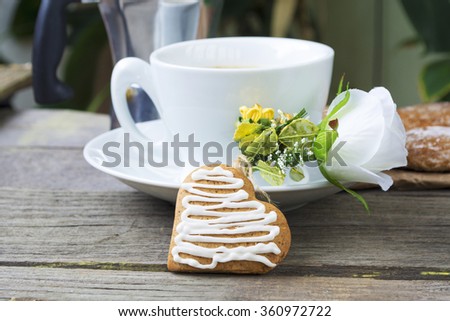 Heart shaped cookies, cup of coffee, bouquet of flowers decoration on old wooden table. sunny morning.romantic breakfast or  Valentine's Day Breakfast. Toned image
