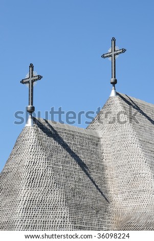 Detail of the roof of a shingle roof of a church with two crosses