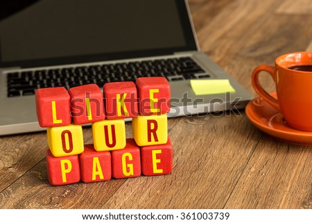 Like Our Page written on a wooden cube in a office desk Royalty-Free Stock Photo #361003739