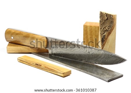 handmade damascus kitchen knife with raw materials isolated on white background