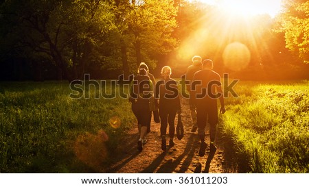 Group of friends walking with backpacks in sunset from back. Adventure, travel, tourism, hike and people friendship concept. Sports activity Royalty-Free Stock Photo #361011203