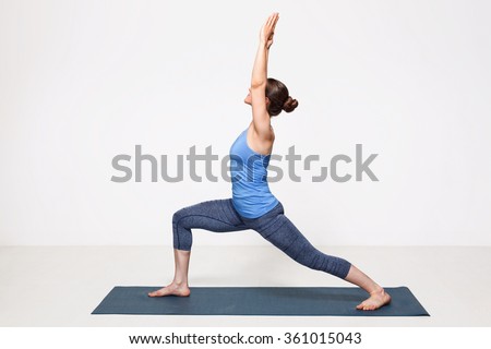 Beautiful sporty fit yogini woman practices yoga asana Virabhadrasana 1 - warrior pose 1 Royalty-Free Stock Photo #361015043