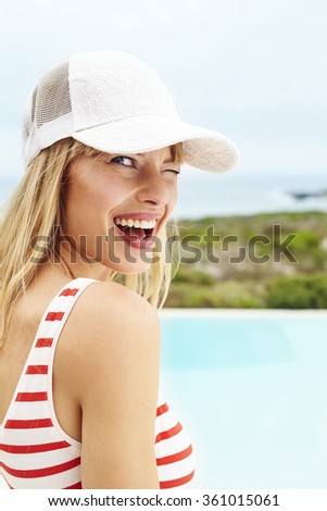 Winking young woman in swimsuit, portrait