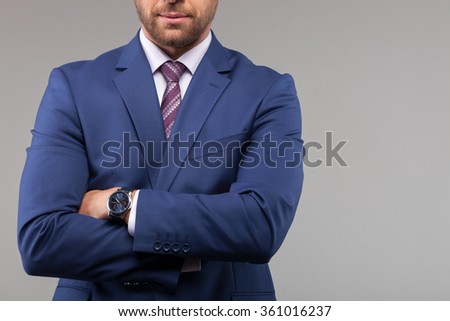 Portrait of handsome man in suit crossed arms confidently. He is standing and posing. Isolated and copy space in right side