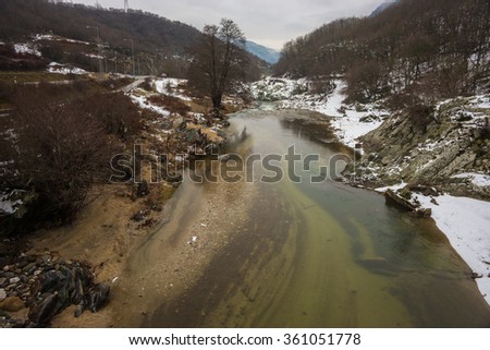 Image of river with green waters, snow and ice near Xanthi in Greece