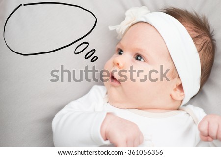 Portrait of cute baby girl lying down and speech bubble