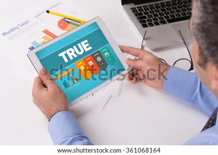 Man working on tablet with TRUE on a screen