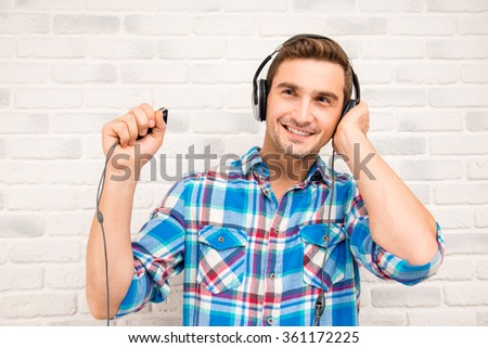 Handsome student listens to music in his ipod Royalty-Free Stock Photo #361172225