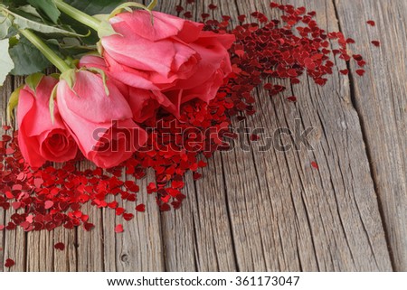 Heap of pink roses on old wooden table