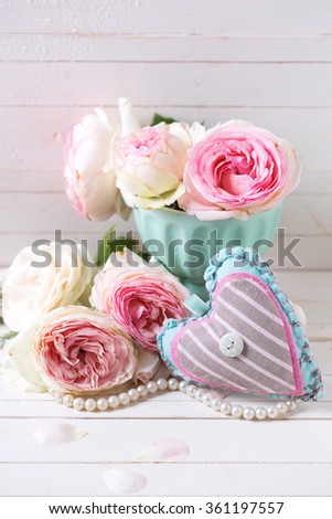 Background with  decorative heart and sweet pink roses flowers  on white painted wooden planks. Selective focus. 

