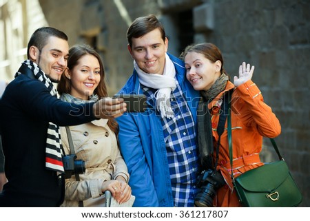 positive tourists taking selfie on camera in smartphone