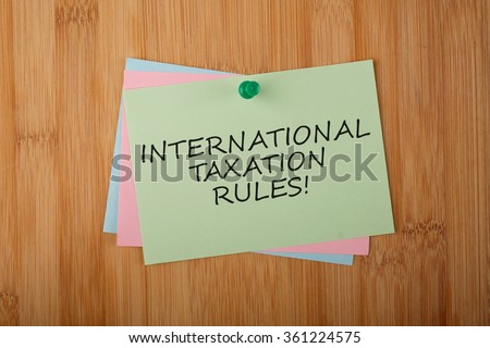 International Taxation Rules! written on green paper note