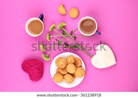 Cup of coffee and cookies with flowers on pink background