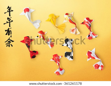 handmade paper craft origami koi carp fish on yellow background. Translation of text: May you have a prosperous new year. 
