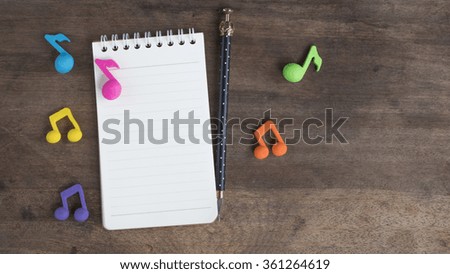 notebook and music note on the old wooden table