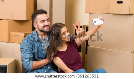 Happy couple making selfies in new home