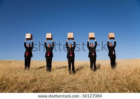 five businessman lineup holding a cardboard box over his head