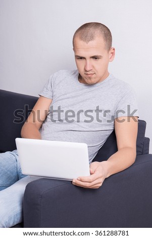 handsome man sitting on sofa with computer at home