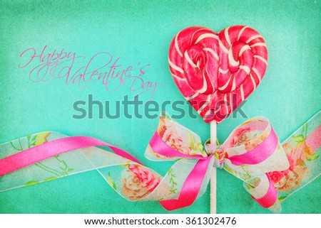 Heart shaped lollipop for Valentine's Day with turquoise background. Copy space background