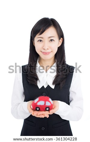 Young business woman holding a car toy, isolated on white background