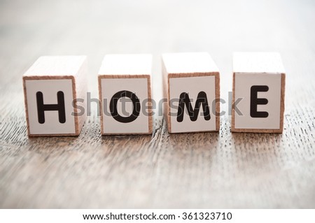 concept word forming with  cube on wooden desk background - Home