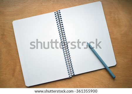 Blank notebook with pen and pencil on wooden table, business concept. Blank notepad with pen on wood texture. Blank sheet. Open notebook for notes and sketches. Background.