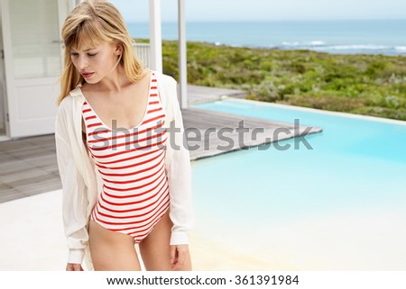 Swimsuit model looking away at poolside