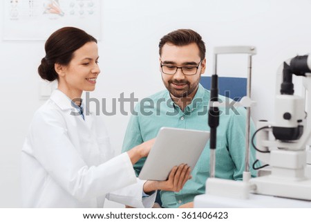 optician with tablet pc and patient at eye clinic Royalty-Free Stock Photo #361406423