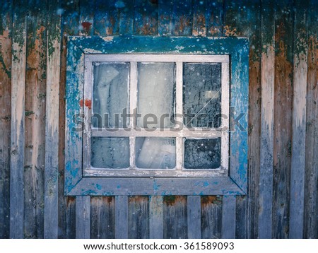 Old window with cracked paint and snow overlay