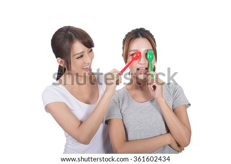 Asian woman with her friend play with spoon.
