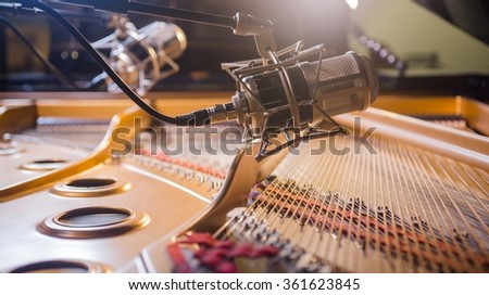Professional microphones recording above grand piano.