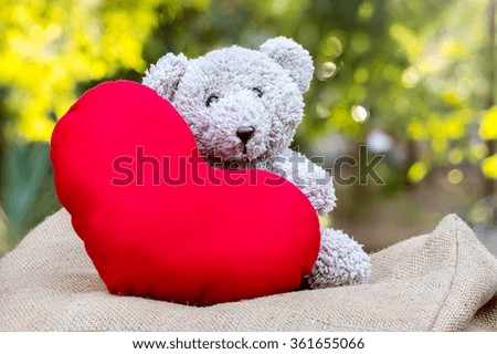 Teddy bears with red hearts with nature background