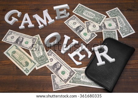 Sign Game Over Dollars And Empty Purse On Wood Background. Concept For  Bankruptcy, Gambling, Fraud, Bribe