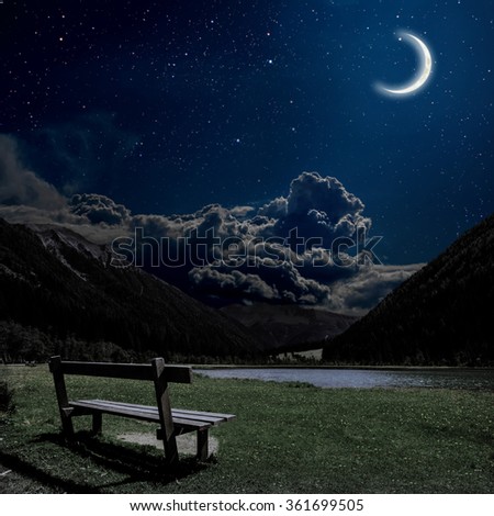 bench for relaxing with a view on the night Alps in Austria. Elements of this image furnished by NASA