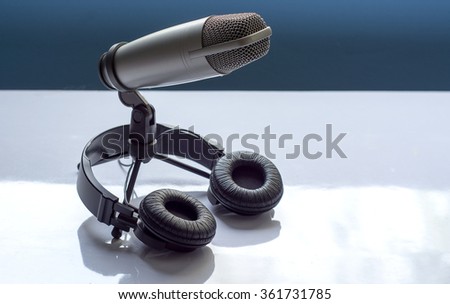 Microphone and headphones on white table. sound editing concept.