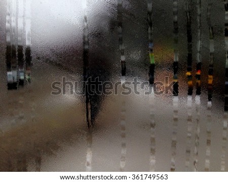 Artistic photo of street through the window with drop of rain 