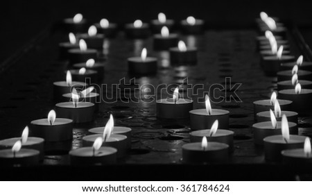 Candles in church. Selective focus. Aged photo. Black and white.