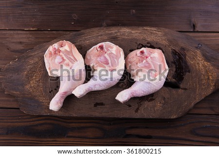 Raw chicken legs on brown wooden background