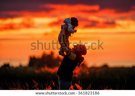 Portrait of picture of happy mother with baby on sunset background