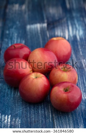 Red shiny apples in wooden basket on blue wooden retro background