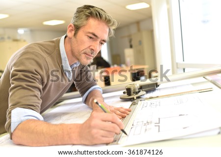 Architect working on drawing table in office Royalty-Free Stock Photo #361874126