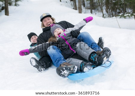 Father and son sledding at winter time