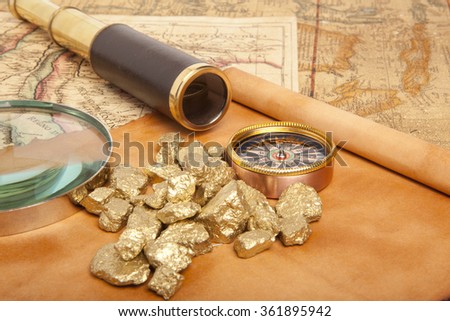 Gold nuggets and vintage brass telescope on antique map 