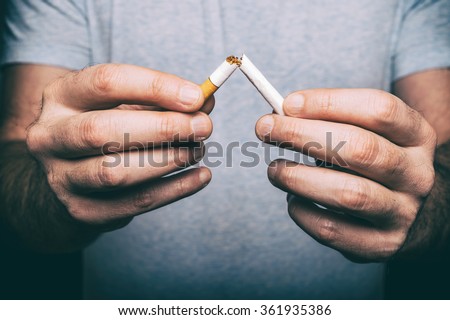 Quit smoking - male hand crushing cigarette Royalty-Free Stock Photo #361935386