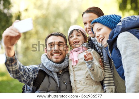 family taking selfie with smartphone outdoors
