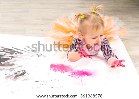 The child, a little girl draws paints 